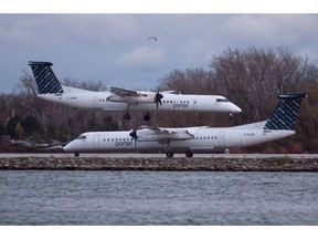 A Porter Airlines plane lands next to a taxiing plane at Toronto's Island Airport on November 13, 2015. Porter Airlines says it hopes it has helped belsnickeling to become a wider Christmas tradition in Nova Scotia. The airline bemused social media users with an article in its in-flight magazine that said belsnickeling is a popular tradition in the province.