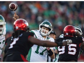 Saskatchewan Roughriders quarterback Zach Collaros, centre, throws the ball as Calgary Stampeders' Ja'Gared Davis, right, closes in during CFL football action in Calgary, Saturday, Oct. 20, 2018. Collaros and the Roughriders return to practice ahead of their CFL West Division semifinal against the Winnipeg Blue Bombers on Sunday.THE CANADIAN PRESS/Jeff McIntosh