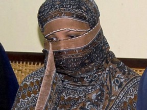 In this Nov. 20, 2010, file photo, Asia Bibi, a Pakistani Christian woman, listens to officials at a prison in Sheikhupura near Lahore, Pakistan. Prime Minister Justin Trudeau says Ottawa is in discussions with Pakistan about the possibility of bringing Bibi, who was recently released from death row, to Canada.