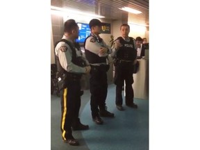 RCMP officers are seen at a Vancouver airport gate Tuesday, Nov. 20, 2018 in this image made from video. RCMP officers were called to a Vancouver airport gate Tuesday night to explain the re-booking and accommodation options to Flair Airlines passengers -- some of whom had been waiting 14 hours -- a job typically handled by airline staff.