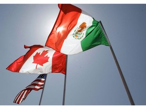 In this April 21, 2008 file photo, national flags representing the United States, Canada, and Mexico fly in the breeze in New Orleans where leaders of the North American Free Trade Agreement met. Democrats are calling for tweaks to Canada's new trade pact with the United States and Mexico as experts warn that economic uncertainty until linger until the deal is ratified in Congress.