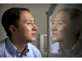 He Jiankui is reflected in a glass panel as he works at a computer at a laboratory in Shenzhen in southern China's Guangdong province, in this Oct. 10, 2018 photo. Canadian researchers have added their voices to widespread international condemnation of a Chinese scientist who says he helped create genetically modified twin girls using a gene-editing tool known as CRISPR. The unconfirmed claim was announced Monday by He Jiankui of China's Southern University of Science and Technology, who said he altered the DNA of embryos during fertility treatments with the goal of preventing the babies from becoming infected with HIV in the future.THE CANADIAN PRESS/ Mark Schiefelbein