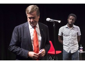 Toronto Mayor John Tory addresses the crowd after being called to the microphone by activist and writer Desmond Cole (right) at an anti-racism meeting in Toronto on Thursday July 14, 2016. Cole was stopped by Vancouver police in what he calls a carding incident.