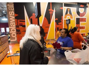 Customers at the checkout at the Loblaws grocery store located in the former Maple Leaf Gardens in Toronto on Thursday, May 1, 2014. A new survey suggests most grocery shoppers spend 32 minutes per visit and approve of those automated self-checkout lanes.