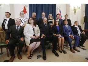 Manitoba's Progressive Conservative government will lay out its agenda for the coming year in the annual speech from the throne at the legislature this afternoon. Premier Brian Pallister, centre, and his ministers laugh during a team photo after he announced a cabinet shuffle at the Manitoba Legislature in Winnipeg on Wednesday, Aug. 1, 2018.