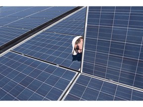 Jason Andriulaitis checks a connection under a new solar panel installation in Scugog, Ont. on Wednesday, April 27, 2016. Installing solar panels already makes sense for most homeowners in Saskatchewan and Ontario but the abundance of cheap hydroelectricity in Quebec and Manitoba means solar power may never make much economic sense in those provinces.