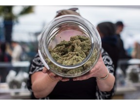 A vendor displays marijuana for sale during the 4-20 annual marijuana celebration in Vancouver on April 20, 2018. Marijuana has been legal in Canada for a month already but immigration lawyers and cannabis executives say when it comes to getting into the United States, the worst may be yet to come. As Canadians get used to the fact that cannabis is no longer against the law in their country, some experts fear they will forget the perils that past and present marijuana use still poses for those seeking to cross the Canada-U.S. border.