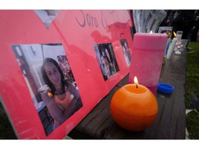 Lit candles and photographs are seen on display at a vigil for Calgary homicide victims Sara Baillie and her five-year-old daughter Taliyah Marsman, in Calgary, on July 17, 2016. A trial is to begin today for a man accused of killing a Calgary woman and her five-year-old daughter in July 2016.
