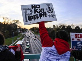 Opponents of the Keystone XL pipeline demonstrate on the Dodge Street pedestrian bridge during rush hour in Omaha, Neb., on Nov. 1, 2017. A federal judge in Montana has blocked construction of the $8-billion Keystone XL pipeline to allow more time to study the project's potential environmental impact.