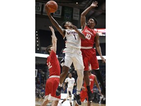 Connecticut's Christian Vital (1) shoots as Cornell's Jack Gordon (32) and Matt Morgan (10) defend during the first half of an NCAA college basketball game, Tuesday, Nov. 20, 2018, in Hartford, Conn.