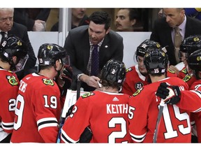 Chicago Blackhawks coach Jeremy Colliton, center, talks to his team during the third period of an NHL hockey game against the St. Louis Blues, Wednesday, Nov. 14, 2018, in Chicago. The Blackhawks won 1-0.