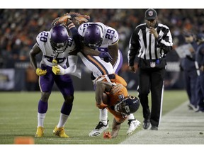 Chicago Bears wide receiver Taylor Gabriel (18) is tackled by Minnesota Vikings cornerbacks Mackensie Alexander (20) and Xavier Rhodes (29) during the first half of an NFL football game Sunday, Nov. 18, 2018, in Chicago.