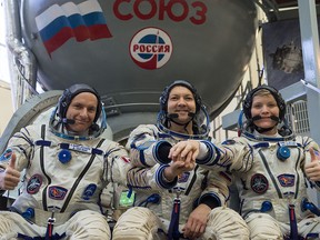 Canadian astronaut David Saint-Jacques, left, Russian cosmonaut Oleg Kononenko and NASA astronaut Anne McClain pose at the Gagarin Cosmonauts' Training Centre in Star City outside Moscow on Nov. 14, 2018. The trio is preparing to head to the International Space Station on Dec. 3, 2018.