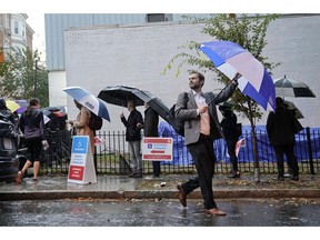 Voters line up in the rain outside Bright Family and Youth Center in the Columbia Heights neighborhood in Washington, Tuesday, Nov. 6, 2018. Across the country, voters headed to the polls Tuesday in one of the most high-profile midterm elections in years.