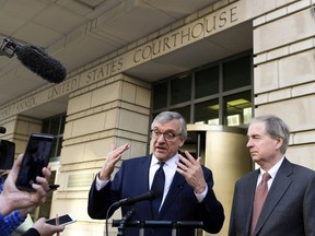 Attorney Paul Kamenar, center, speaks to reporters outside federal court in Washington, Thursday, Nov. 8, 2018, as Peter Flaherty, right, Chairman and Chief Executive Officer of the National Legal and Policy Center, listens. Judges on a federal appeals court heard arguments from Kamenar and are weighing whether to invalidate the Russia investigation over arguments made a former aide to longtime Trump confidante Roger Stone that the special counsel's appointment was unconstitutional.