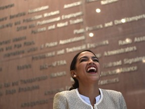 Rep.-elect Alexandria Ocasio-Cortez, D-N.Y., laughs as another speaker talks about her during a news conference with members of the Progressive Caucus in Washington, Monday, Nov. 12, 2018.
