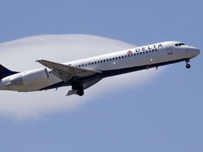 In this May 24, 2018, file photo a Delta Air Lines passenger jet plane, a Boeing 717-200 model, approaches Logan Airport in Boston. A black female doctor says she was questioned several times by other flight attendants, on her medical credentials, when she assisted a passenger next to her who was showing signs of distress.
