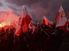FILE - In this Saturday, Nov. 11, 2017, file photo, Demonstrators burn flares and wave Polish flags during the annual march to commemorate Poland's National Independence Day in Warsaw, Poland. Thousands of nationalists marched in Warsaw on Poland's Independence Day holiday, taking part in an event that was organized by far-right groups.