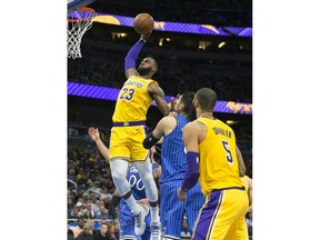 Los Angeles Lakers forward LeBron James (23) slams the ball over Orlando Magic center Nikola Vucevic (9) in the first half of an NBA basketball game, Saturday, Nov. 17, 2018, in Orlando, Fla.