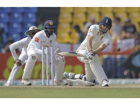 England's James Anderson plays a shot as Sri Lankan wicketkeeper Niroshan Dickwella watches during the fourth day of the second test cricket match between Sri Lanka and England in Pallekele, Sri Lanka, Saturday, Nov. 17, 2018.