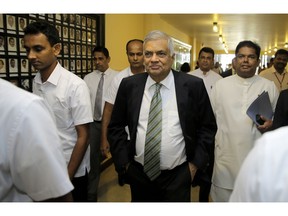 Sri Lanka's ousted prime minister Ranil Wickeremesinghe, center, arrives in Colombo, Sri Lanka, Thursday, Nov. 29, 2018.  Sri Lankan lawmakers have approved a motion barring disputed Prime Minister Mahinda Rajapaksa from using state funds after he was defeated in a no confidence vote.