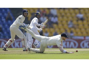 England's Ben Stokes, bottom, dives to stop a ball as wicketkeeper Ben Foakes and Sri Lankan batsman Dhananjaya de Silva watch the ball as they filed during the second day of the second test cricket match between Sri Lanka and England in Pallekele, Sri Lanka, Thursday, Nov. 15, 2018.