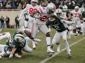 Ohio State wide receiver Parris Campbell (21) leaps over Michigan State linebacker Byron Bullough (38) to score on a 1-yard run during the first half of an NCAA college football game, Saturday, Nov. 10, 2018, in East Lansing, Mich.
