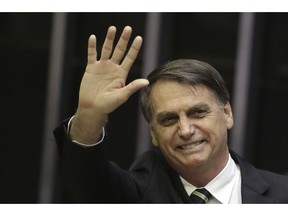 President-elect Jair Bolsonaro waves at a ceremony to celebrate the 30th anniversary of Brazil's constitution at the National Congress, in Brasilia, Brazil, Tuesday, Nov. 6, 2018. Bolsonaro is insisting on his respect for the country's constitution, implicitly responding to fears his administration might roll back civil rights.