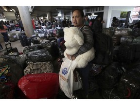 A Cuban doctor clutching a teddy bear prepares to depart the airport with her colleagues in Brasilia, Brazil, Thursday, Nov. 22, 2018. Cuba announced it is recalling the physicians in the "More Doctors" program after Brazilian President-elect Jair Bolsonaro said the program could continue only if doctors get their full pay directly rather from the Cuban government and are able to bring their families with them.