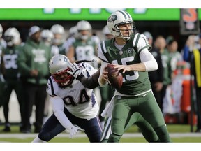 New York Jets quarterback Josh McCown (15) looks to pass during the first half of an NFL football game as New England Patriots defensive end Adrian Clayborn (94) rushes him Sunday, Nov. 25, 2018, in East Rutherford, N.J.