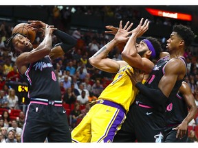 Miami Heat guard Josh Richardson, left, Los Angeles Lakers center JaVale McGee, center, and Heat center Hassan Whiteside are unable to come up with a rebound during the first half of an NBA basketball game, Sunday, Nov. 18, 2018, in Miami.