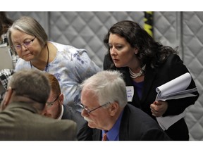 Democratic party observer Rachel May Zysk, right, looks on a volunteers check under and over votes during an elections manual recount for three undecided races Friday, Nov. 16, 2018, in Tampa, Fla.  Florida's bitter U.S. Senate contest is headed to a legally required hand recount after an initial review by ballot-counting machines showed Republican Gov. Rick Scott and Democratic Sen. Bill Nelson separated by less than 13,000 votes.