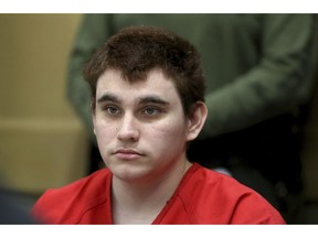 FILE - In this Aug. 15, 2018 file photo, Florida school shooting suspect Nikolas Cruz listens during a status check on his case at the Broward County Courthouse in Fort Lauderdale, Fla. Authorities say Cruz attacked a detention officer at the county jail, Tuesday, Nov. 13,  and now faces new charges. Cruz is charged with killing 17 people and wounding 17 others in the Feb. 14 mass shooting at Marjory Stoneman Douglas High School.