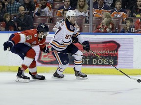 Edmonton Oilers center Connor McDavid (97) skates with the puck as Florida Panthers defenseman Aaron Ekblad (5) defends during the first period of an NHL hockey game, Thursday, Nov. 8, 2018, in Sunrise, Fla.