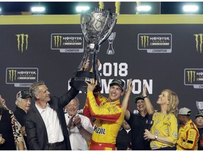 Joey Logano holds the trophy after winning the NASCAR Cup Series Championship auto race at the Homestead-Miami Speedway, Sunday, Nov. 18, 2018, in Homestead, Fla.