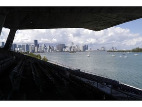 In this Wednesday, Sept. 19, 2018 photo, the skyline of downtown Miami is seen from Miami Marine Stadium on Virginia Key, in Miami. The stadium was once the home to world-class events such as concerts and speedboat races. The city condemned the modernist concrete structure after Hurricane Andrew devastated South Florida in 1992. The city has announced its intentions to restore the derelict stadium.