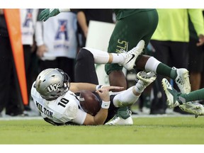 Central Florida  quarterback McKenzie Milton goes down with an apparent knee injury after being tackled during the first half of an NCAA college football game against South Florida Friday, Nov. 23, 2018, in Tampa, Fla.