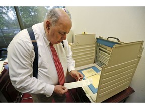 In this Tuesday, Nov. 13, 2018, photo, former Judge Robert Rosenberg, shows how an original ballot and Votomatic voting booth were used in the 2000 election as he speaks during an interview with The Associated Press, at his office in Plantation, Fla. Rosenberg was on the Broward County Canvassing Board during the 2000 presidential election between George W. Bush and Al Gore.