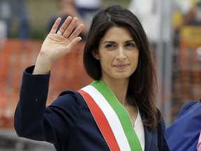 FILE - In this Thursday, June 23, 2016 file photo, Rome's Mayor Virginia Raggi waves to reporters in Rome. A verdict is nearing for Rome's mayor, on trial for allegedly lying about a City Hall hire. Testimony ended Friday, Nov. 9, 2018 in the trial of Virginia Raggi, the most prominent mayor from the populist 5-Star Movement. Prosecutors allege she lied to anti-corruption officials when she insisted she alone picked the head of the city tourist office.