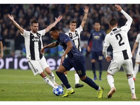 ManU forward Anthony Martial, center, runs with the ball in between Juventus midfielder Miralem Pjanic, left, and Mattia De Sciglio, during the Champions League group H soccer match between Juventus and Manchester United at the Allianz stadium in Turin, Italy, Wednesday, Nov. 7, 2018.