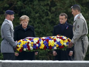 French President Emmanuel Macron and German Chancellor Angela Merkel lay a wreath of flowers in the Clairiere of Rethondes where the armistice was signed in a railway carriage in the pre-dawn hours of Nov. 11, 1918, in Compiegne, north of Paris.