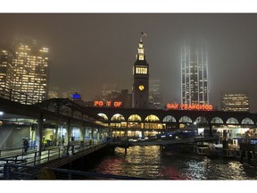 In this photo taken Tuesday, Nov. 27, 2018, rain showers begin to diminish at the Ferry Building in San Francisco. Forecasters say California will see widespread rain and heavy Sierra Nevada snowfall starting late Wednesday that could create travel problems and unleash damaging runoff from wildfire burn scars.