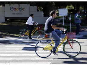 FILE - In this Oct. 20, 2015 file photo, employees ride company bicycles outside Google headquarters in Mountain View, Calif. Hundreds of Google employees are expected to temporality leave their jobs Thursday morning Nov. 1, 2018, in a mass walkout protesting the internet company's lenient treatment of executives accused of sexual misconduct.