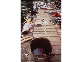 FILE - In this Nov. 20, 1978 file photo, a vat that contained a drink laced with deadly cyanide sits on a sidewalk at Peoples Temple in Jonestown, Guyana. The bodies of followers that drank the poison are strewn around the commune. Dozens of Peoples Temple members in Guyana survived the mass suicides and murders of more than 900 because they had slipped out of Jonestown or happened to be away Nov. 18, 1978. Those raised in the temple or who joined as teens lost the only life they knew. They have journeyed over the past 40 years through grief over lost loved ones, feeling like pariahs, building new lives and, finally, acknowledging that many had a role in enabling the Rev. Jim Jones to seize control over his followers.