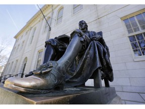 FILE - In this March 13, 2016 file photo, a sculpture in bronze of John Harvard rests on the campus of Harvard University, in Cambridge, Mass. People often touch the toe of the statue's shoe for luck. A federal judge in Boston is scheduled to hear closing arguments Friday, Nov. 2, 2018, in a highly publicized lawsuit alleging that elite Harvard discriminates against Asian-Americans. Much of the spotlight has been on affluent Chinese-Americans with stellar academic scores who say the college rejects Asians in favor of lesser-qualified applicants. They say factoring in race hurts Asian-Americans.