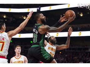 Boston Celtics forward Marcus Morris shoots as guard Jeremy Lin, left, and forward DeAndre' Bembry, right, defend during the first half of an NBA basketball game Friday, Nov. 23, 2018, in Atlanta.