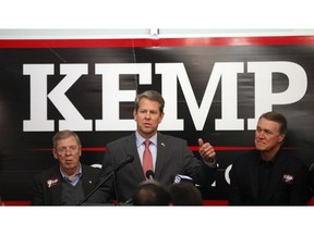 Georgia Republican gubernatorial candidate Brian Kemp, center, speaks to volunteers as Sen. Johnny Isakson (R-Ga), left, and Sen David Perdue (R-Ga) looks on during a stop at a campaign office Monday, Nov. 5, 2018, in Atlanta. Kemp is in a close race with Democrat Stacey Abrams.