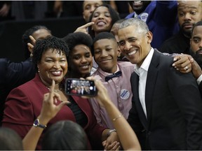 Former President Barack Obama and Democratic candidate for Georgia Governor Stacey Abrams pose for a photograph with two unidentified family members after a campaign rally at Morehouse College Friday, Nov. 2, 2018, in Atlanta.