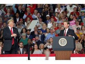 Georgia Republican gubernatorial candidate Brian Kemp, right, speaks as President Donald Trump looks on during a rally for Sunday, Nov. 4, 2018, in Macon, Ga.