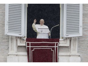 Pope Francis waves to faithful during the Angelus noon prayer he delivered from his studio's window overlooking St. Peter's Square at the Vatican, Sunday, Nov. 4, 2018.